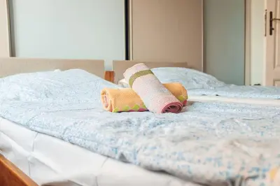 two rolled up towels sitting on a bed at Rustic Central Belgrade Stay in Belgrade