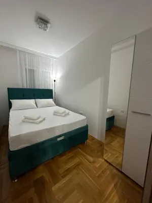 a bedroom with a bed with white sheets and a mirror at Port 3 in Belgrade