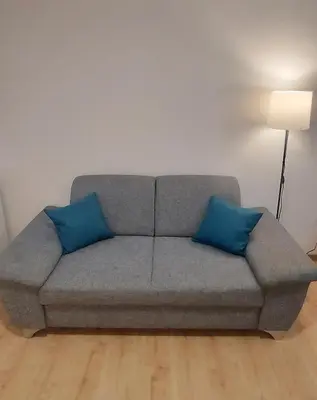 a couch with two blue pillows in a living room at Magenta Garden in Belgrade