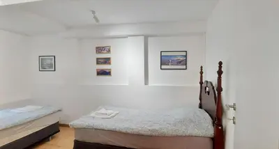 a bedroom with two beds and paintings on the wall at Magenta Garden in Belgrade