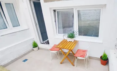 a patio with a wooden table and two chairs at Magenta Garden in Belgrade