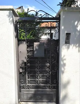 a black iron gate with a plant on top at Magenta Garden in Belgrade