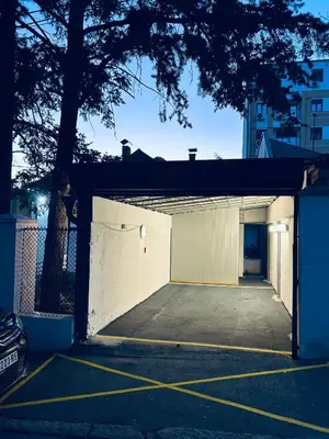 a parking lot with a large white garage at Magenta Garden in Belgrade