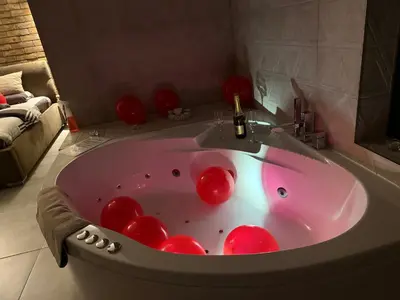 a pink bath tub with red balls in a bathroom at Apartman North in Mladenovac