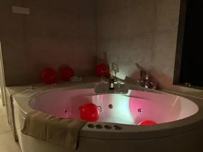 a pink bath tub with a sink in a bathroom at Apartman North in Mladenovac