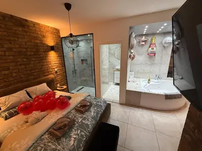 a bathroom with a bed and a bath tub and a sink at Apartman North in Mladenovac