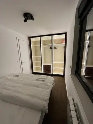 a white bed in a room with a large window at Apartment Belgrade GV (free garage) in Vračar (historical)
