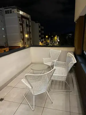 three chairs and a table on a balcony at night at Apartment Belgrade GV (free garage) in Vračar (historical)