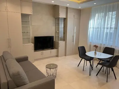a living room with a couch and a table and a tv at Sveti Stefan in Belgrade