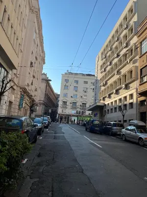 an empty city street with parked cars and buildings at Sveti Stefan in Belgrade