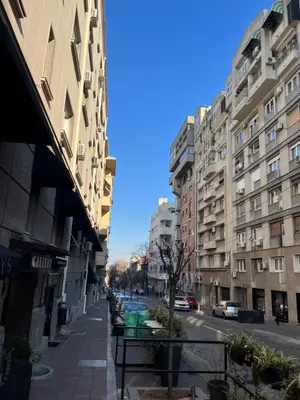 a city street with tall buildings and a street with benches at Sveti Stefan in Belgrade
