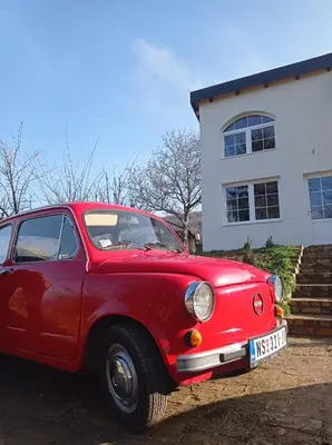 a red car parked in front of a house at Vikendica Smokvica in Sremski Karlovci