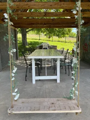a table and chairs under a wooden pergola at Vikendica Smokvica in Sremski Karlovci