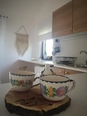 two cups sitting on a cutting board in a kitchen at Apartman Snežana Jugovo in Smederevo